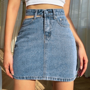Détail d'une mini-jupe en jean bleu clair avec double taille évidée et bouton en métal