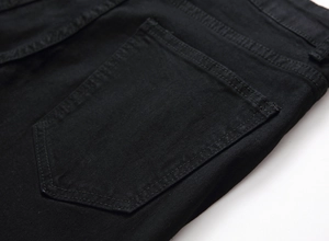 Detail of classic black denim jeans showing rear pentagonal pocket and double-stitch seam