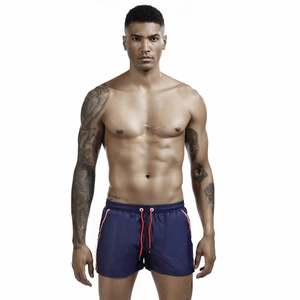 Detailed view of navy blue swim trunks with red drawstring and side stripe accents