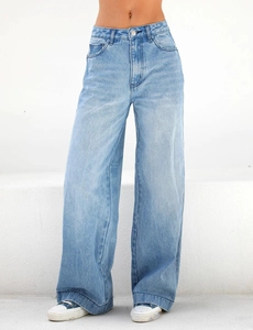 Detail of high-waisted light blue wide-leg jeans with metal button and side pockets