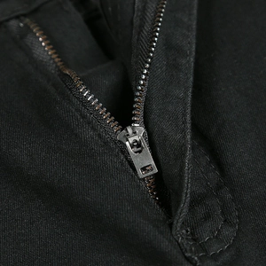 Vue macro des détails de la fermeture éclair métallique sur un jean skinny noir