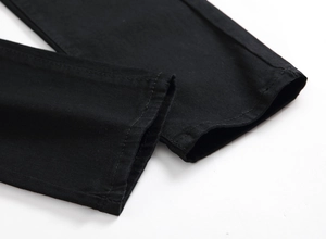 Close-up of the double-needle stitched hem on these black slim fit twill denim pants