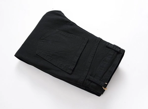 Detail view of the back pocket and stitching on these black embroidered rose denim jeans