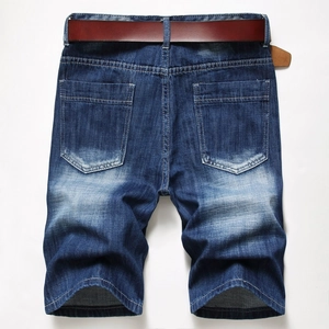 Macro view of blue washed denim shorts featuring back pockets and a classic brown belt