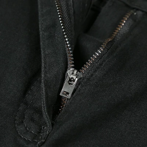 Détail de la braguette à fermeture éclair métallique sur jean noir pour homme