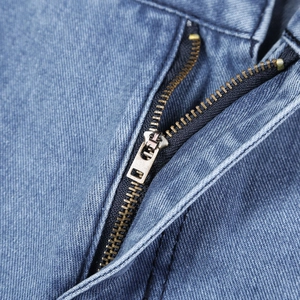 Macro shot of high waist blue jeans showing the metal zipper detail and durable stitching