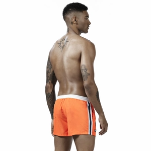 Men's orange athletic shorts with elastic waist and side stripes on white background