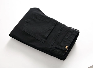 Detail of black denim fabric texture with reinforced back pocket stitching and belt loops