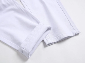 Détail du bas de jean motard blanc montrant la double couture et l'ourlet replié de qualité