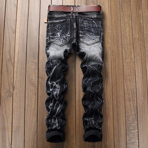 Détail de la texture denim gris délavé avec effet marbré et ceinture en cuir marron incluse