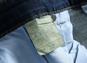 Gros plan détaillé sur l'étiquette de lavage et la taille d'un jean bleu foncé pour homme