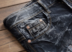 Gros plan détaillé du jean denim gris foncé montrant les coutures et les rivets
