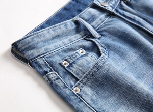 Detail view of light blue denim shorts with metal rivets and reinforced stitching