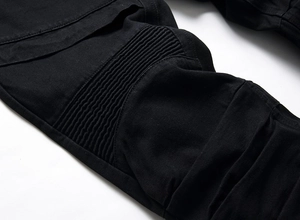 Détail des plis biker et des coutures renforcées sur le pantalon de moto noir pour homme