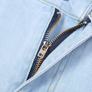 Detail view of premium washed denim fabric and high-quality bronze metal zipper closure