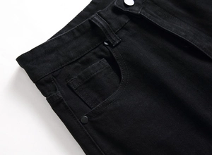 Gros plan sur la taille d'un jean noir avec poches classiques et bouton en métal mat