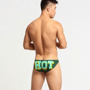 Dettaglio slip uomo a vita bassa con stampa HOT gialla audace su tessuto verde scuro