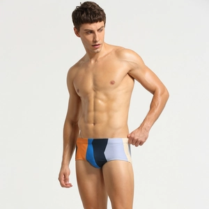 Detail of men's low waist trunks featuring geometric orange and navy color block panels