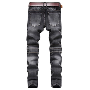 Détails du jean de moto avec empiècements nervurés aux genoux et ceinture brune