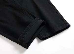 Détail du jean motard noir pour homme montrant le tissu en sergé et l'ourlet replié