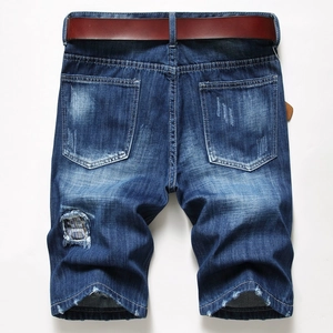 Detail of men's vintage denim shorts featuring retro patchwork and whisker washing effects