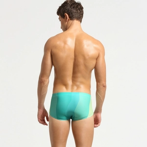 Rear view of men's low-rise blue swim trunks with wave patterns and tight fit design