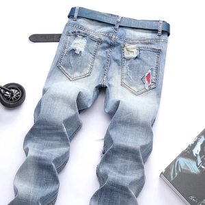 Men's slim fit light blue distressed jeans with vintage whiskers and red patch detail