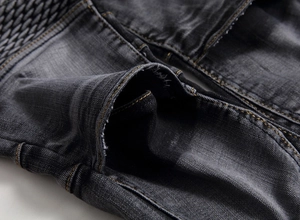 Gros plan sur un jean gris foncé avec coutures contrastées jaunes sur la poche avant
