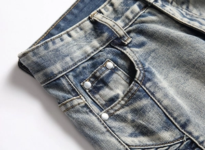 Detail of vintage blue denim jeans featuring waist structure and coin pocket with rivets