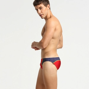 Gros plan sur le slip de bain bicolore rouge et violet avec passepoil doré et taille élastique