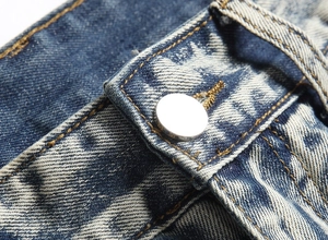 Detailed macro view of denim snow wash fabric with silver button and contrast yellow stitching