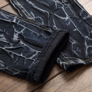 Jean bleu foncé pour hommes avec effet délavé marbré et détails déchirés