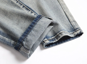 Detailed macro view of light blue denim jeans hem with wash effects and stitching