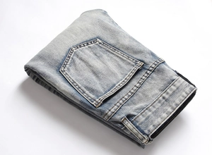 Detailed back pocket view of light blue distressed denim jeans with vintage wash