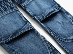 Détail des coutures plissées aux genoux et délavage rétro sur jean biker bleu