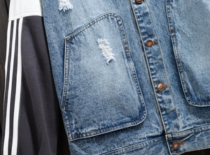 Close-up of contrast stitching on denim jacket with vintage metal buttons and stripes