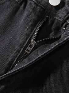 Nahaufnahme von silbernem Metallreißverschluss und Knopf an schwarzer Distressed-Jeans