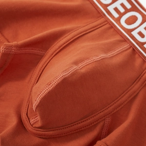 Macro shot of rust red knit cotton fabric texture and flatlock seams on men boxers