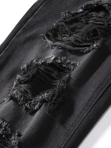 Detailaufnahme von schwarzem Denim mit distressed Rissen und ausgefransten Stofftexturen