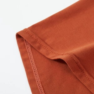 Close-up of rust red men's knitted boxers showing premium double-stitched hem details