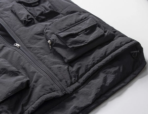 Detail of outdoor utility vest featuring multiple 3D cargo pockets and mesh pockets