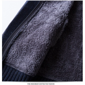 Detail of men's navy knit sweater with thick grey sherpa lining and ribbed hem