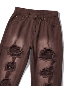 Detailansicht der kaffeebraunen Destroyed-Jeans mit ausgefransten Löchern und weißen Fäden