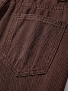 Makroaufnahme der Gesäßtasche an braunen Ripped Jeans mit hochwertiger Köperbindung