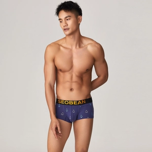Detailed view of men's low-rise boxer briefs with geometric patterns on a fit model