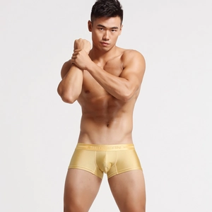 Detail of men's golden nylon boxer briefs with wide elastic waistband and silky texture