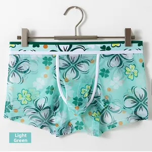 Close-up of light green ice silk boxer briefs featuring clover print and mesh fabric