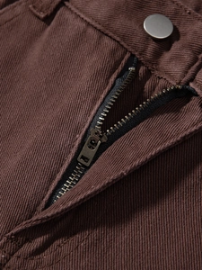 Detailaufnahme der braunen Jeans-Taille mit Bronze-Reißverschluss und Silberknopf