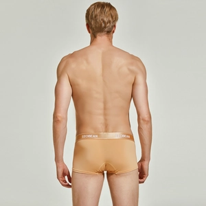 Rear view of men's low-rise knit trunks in beige with a wide elasticated logo waistband