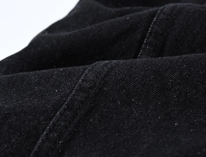 Close-up of black denim fabric with durable twill weave and double-stitched seams